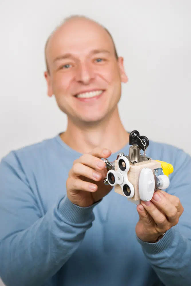 DEBATIN_Produktsparten_Headerbild_DEBADEINS_Tröber_Würfel Dr.-Ing. Oliver Tröber tient un fidget cube dans la main.