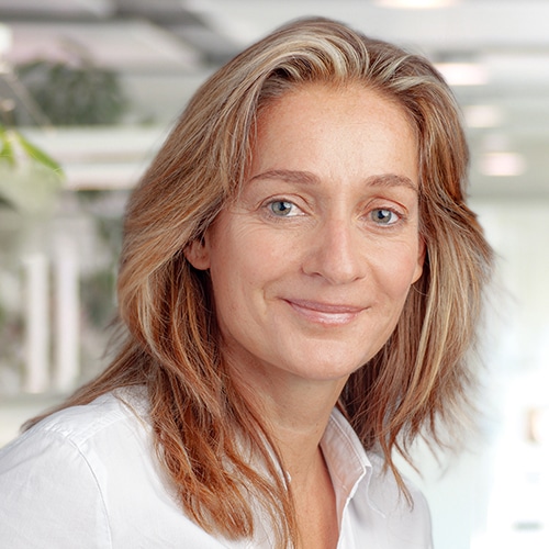 Portrait d’Eva-Maria Schneider, une femme aux cheveux brun-blond mi-longs, souriant gentiment à la caméra et portant une chemise blanche. Elle travaille comme Consultante commerciale / Service client chez Debatin.