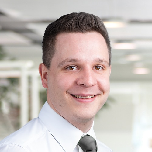 Portrait de Michael Hoffmann, un homme au regard amical avec des cheveux bruns courts. Il porte une chemise blanche et une cravate sombre. Michael Hoffmann est Consultant commercial / Service client chez DEBATIN.