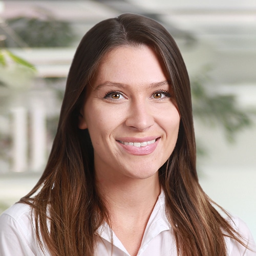 Gros plan de Vanessa Dittrich, une femme souriante avec de longs cheveux foncés portant une chemise blanche. Elle travaille comme Consultante commerciale / Service client chez Debatin.