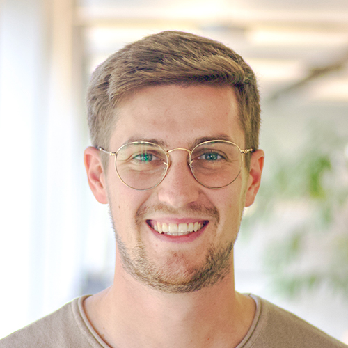 Photo portrait de Luca Rupertus, service Achats Techniques chez DEBATIN, devant un arrière-plan de bureau lumineux.